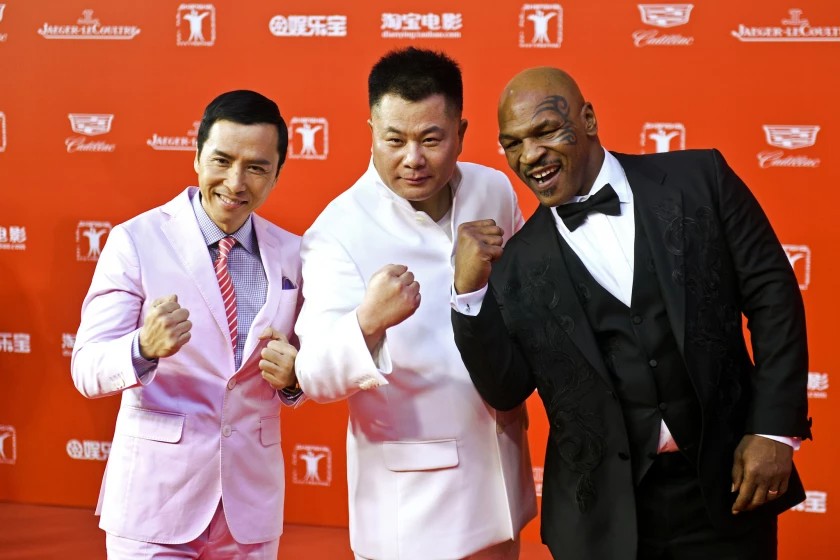Doanh nhân Trung Quốc Shi Jianxiang (ở giữa) chụp hình cạnh Chân Tử Đan (trái) và Mike Tyson (phải) tại LHP Thượng Hải năm 2015. Ảnh: ChinaFotoPress / Getty